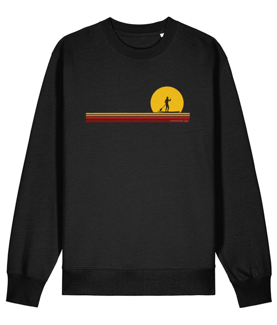 Black Nanook23 First Light organic cotton sweatshirt with a paddleboarder silhouetted against a yellow sun above stripes of yellow, orange and red.